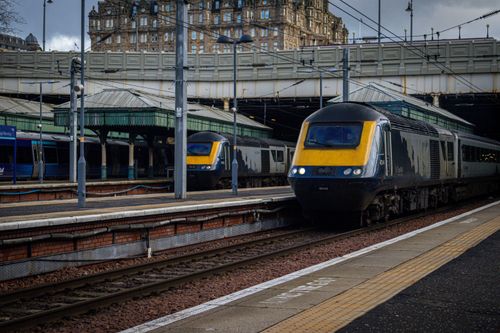 Free Busy scene of trains arriving at Edinburgh Waverley Station, Scotland on a cloudy day. Stock Photo