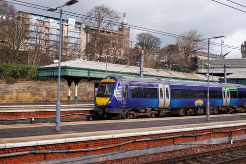 Free A Scotrail train waits at Edinburgh's historic railway station on a cloudy day. Stock Photo