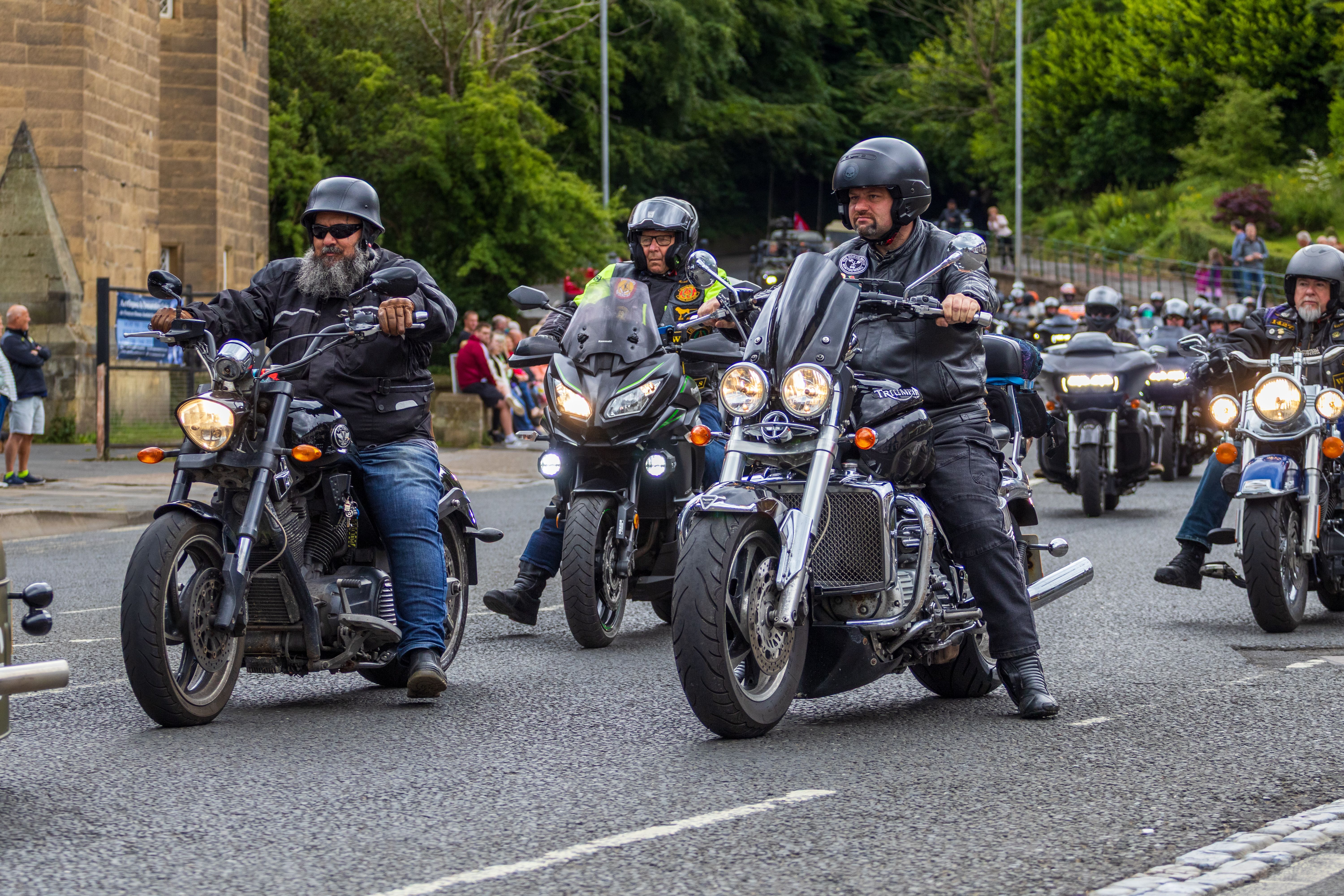 Bikers cruise through Morpeth, England, showcasing diverse motorcycles in a lively parade.