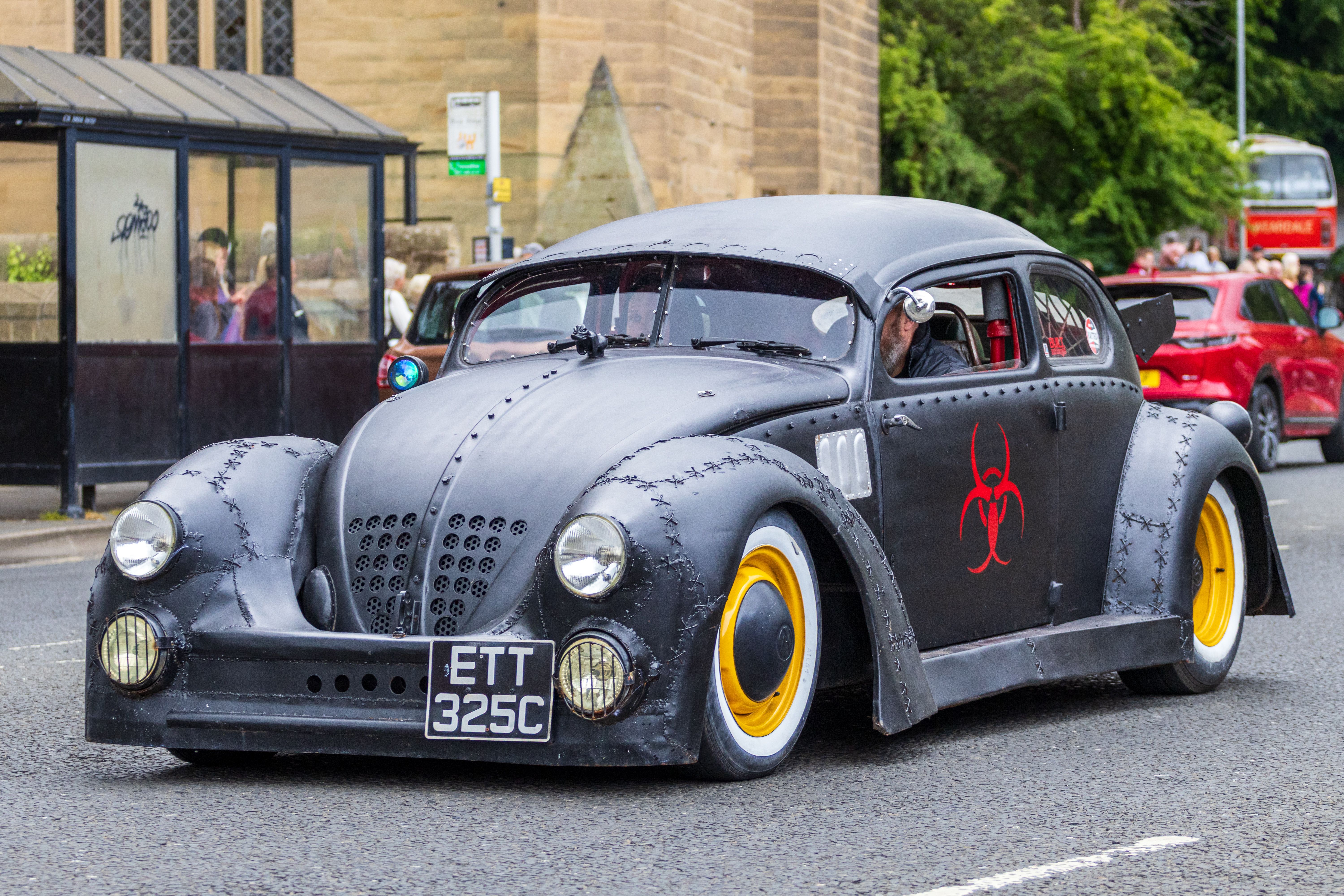 Custom vintage car with biohazard symbol on display in Morpeth, UK, showcasing unique design.