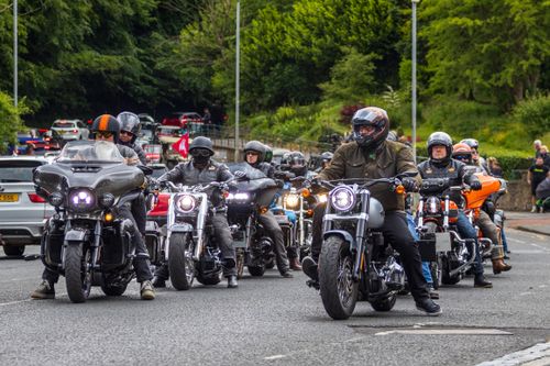 Free Group of motorcyclists riding through Morpeth, England, on a clear day, showcasing biker culture. Stock Photo