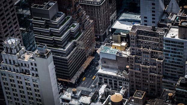 Aerial view of skyscrapers and streets in downtown New York City, featuring iconic urban architecture.