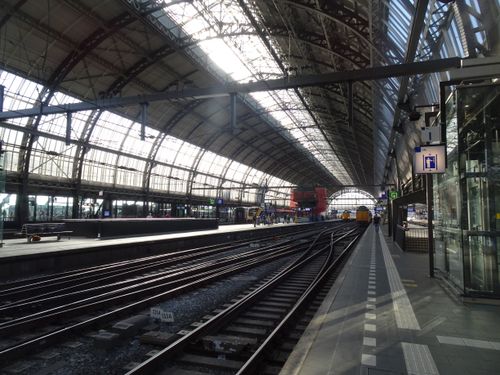 Free Interior of Amsterdam Centraal station showcasing modern architecture and railway tracks. Stock Photo