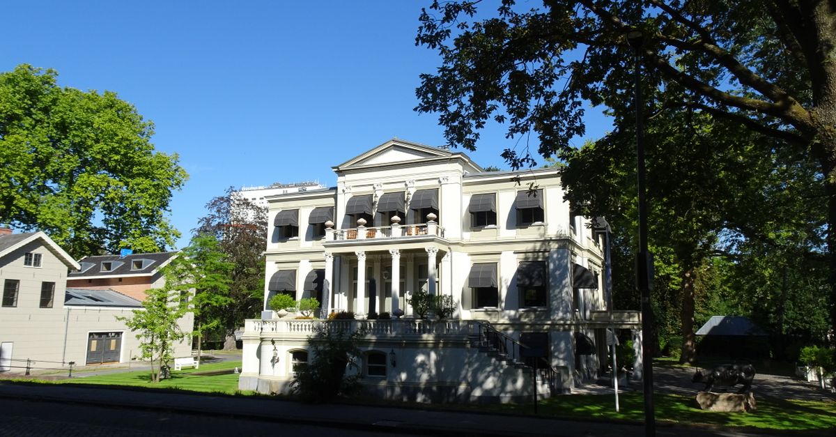 A beautiful neoclassical building surrounded by trees in Rotterdam, Netherlands.