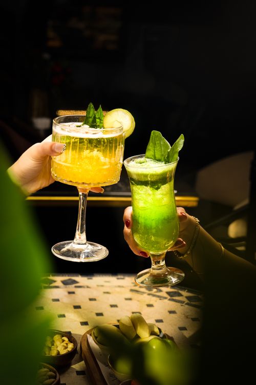 Free Bright, refreshing cocktails with lime and mint in elegant glassware, perfect for summer evenings. Stock Photo
