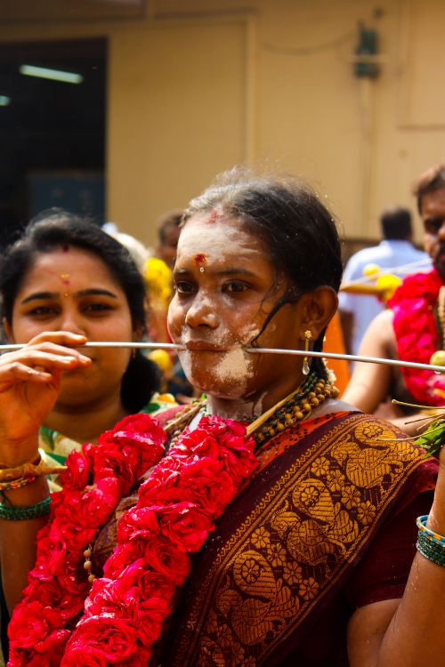 Free A woman participates in a traditional festival with ritualistic piercing, adorned in vibrant attire. Stock Photo