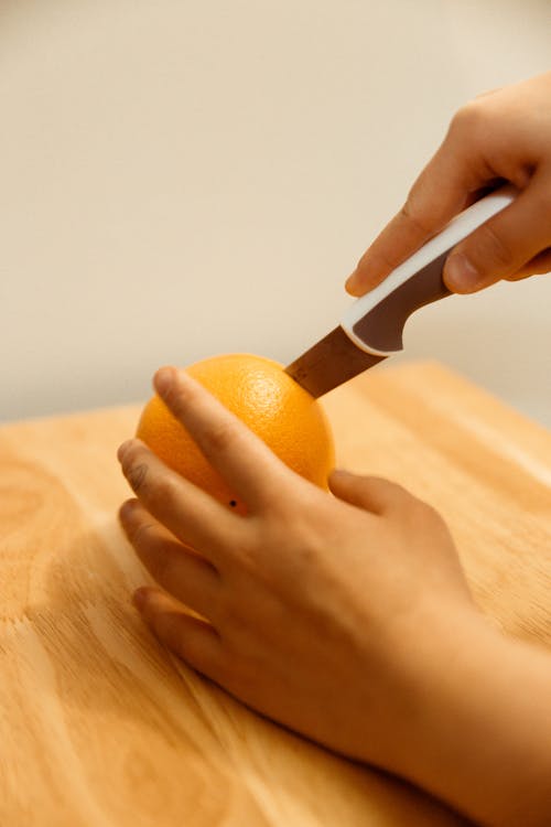 Person Slicing An Orange Fruit