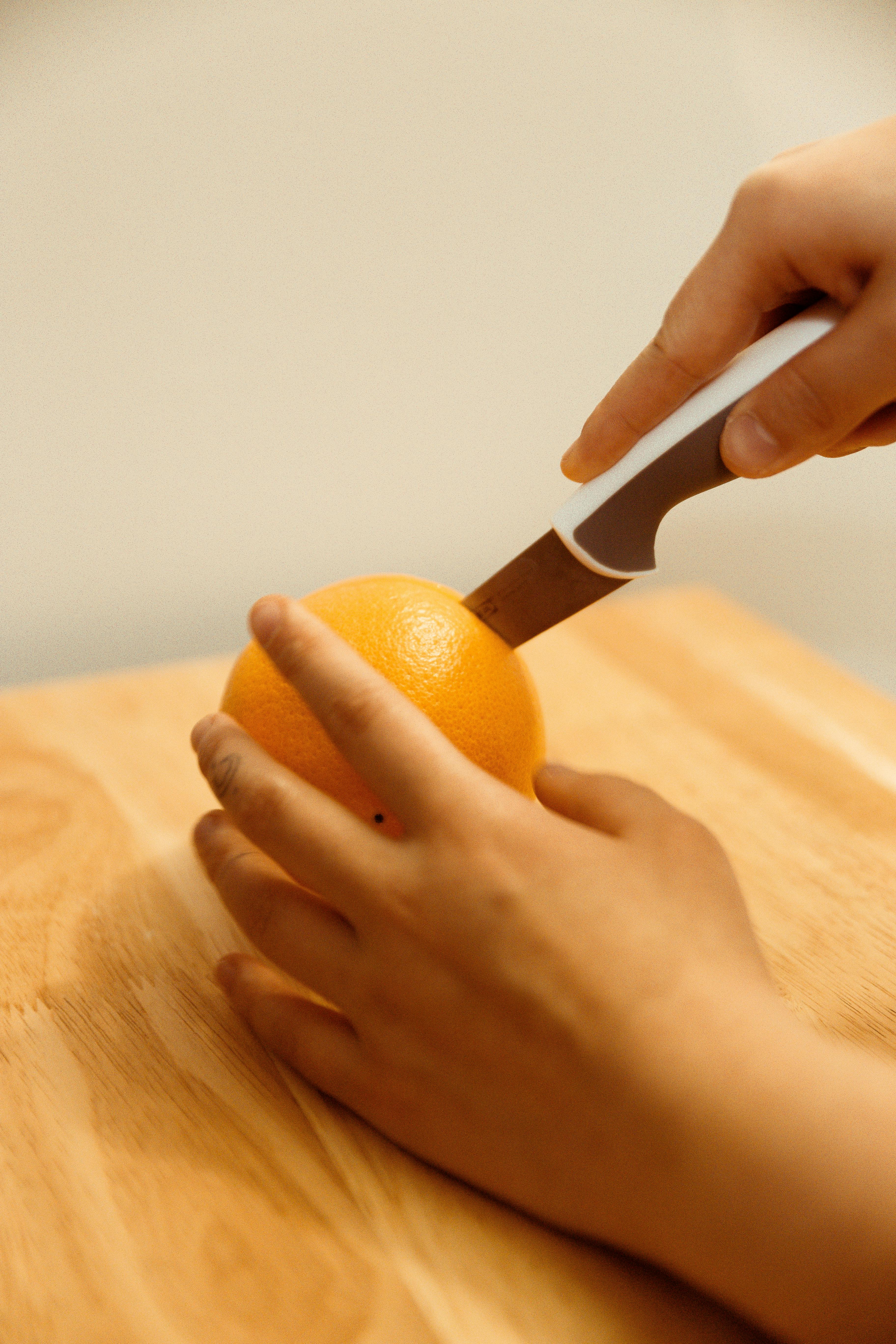 Person Slicing An Orange Fruit · Free Stock Photo