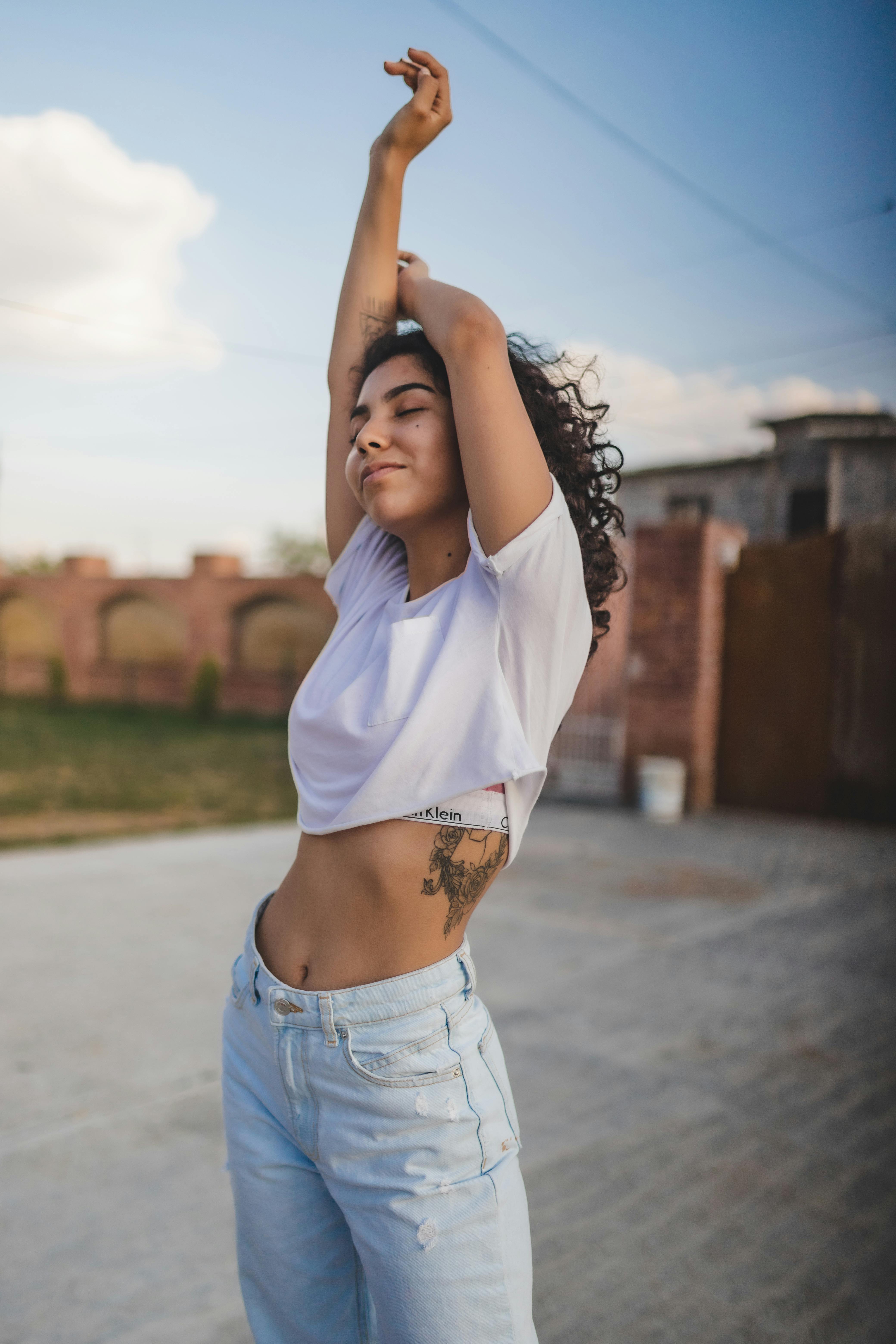 Woman In White Crop Top And Blue Denim Jeans Raising Her, 57% OFF