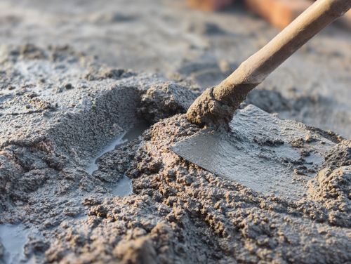 Free Detailed image of a shovel mixing wet cement, showcasing construction work. Stock Photo