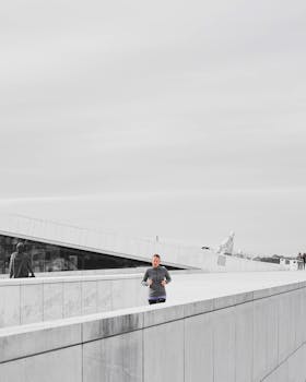 A woman jogging on the rooftop of the Oslo Opera House, Norway, showcasing modern architecture and leisure activity.