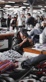 An elderly man closely examines merchandise with a magnifying glass in a bustling Istanbul market.
