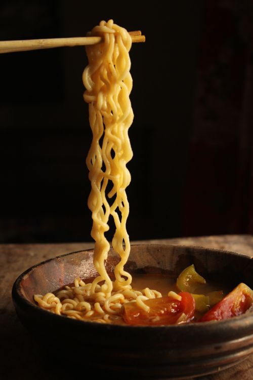 Free Warm ramen noodles lifted with chopsticks, capturing an inviting savory meal moment. Stock Photo