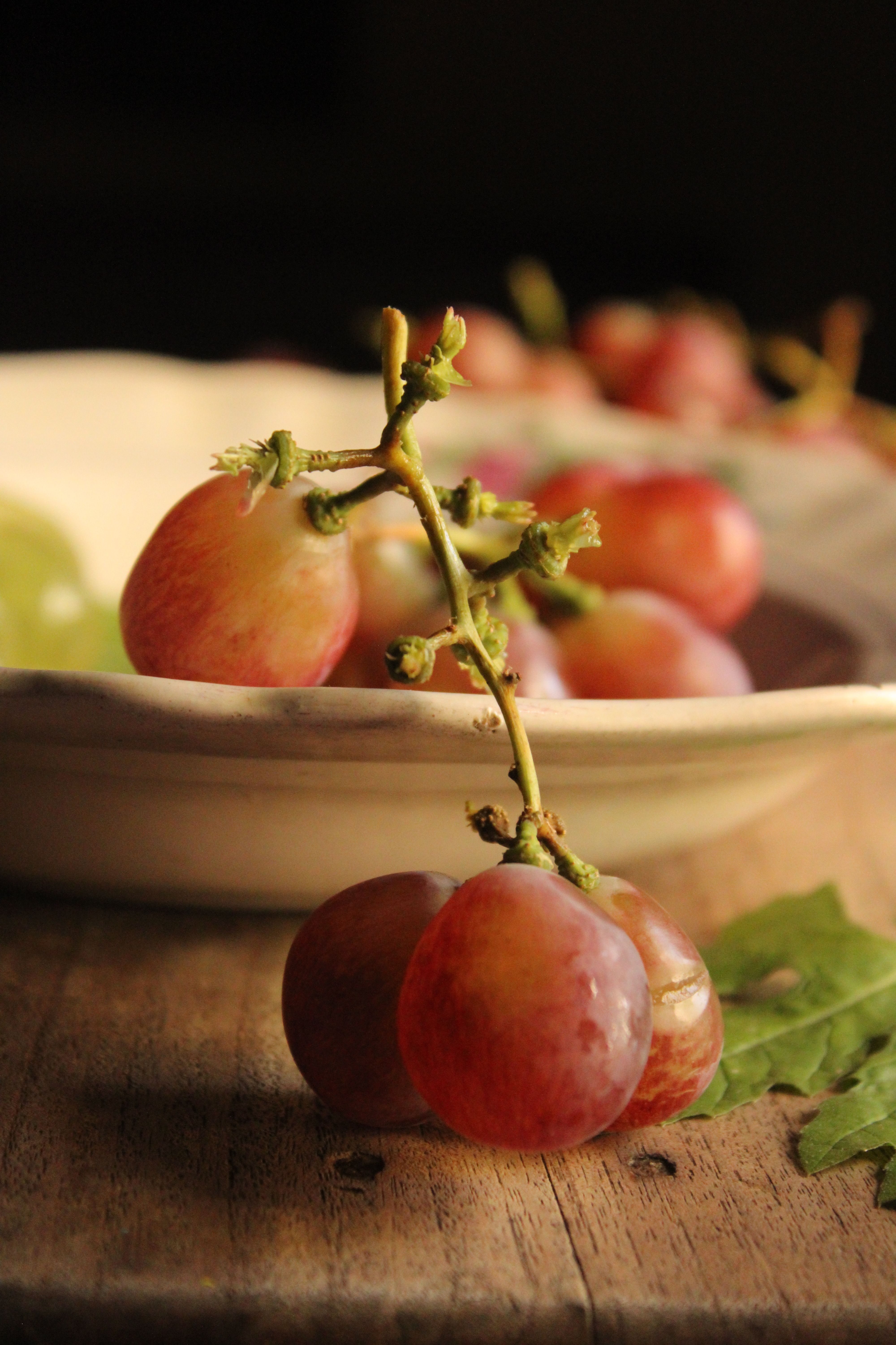 Fotomural Primer plano estético de uvas rojas maduras sobre una mesa de madera, perfecto para temas de estilo de vida y gastronomía.
