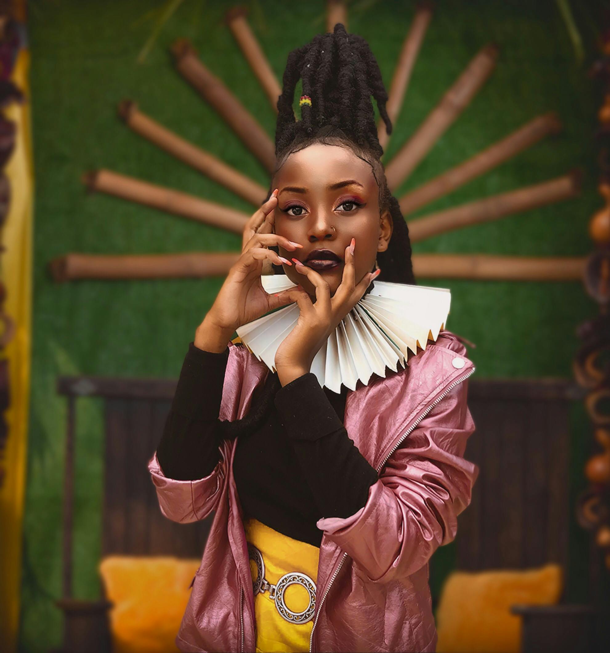 Portrait of a stylish African woman with a creative pose and vibrant fashion in an artistic setting.