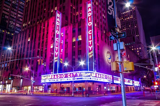Illuminated facade of Radio City Music Hall glowing in neon at night in New York City.