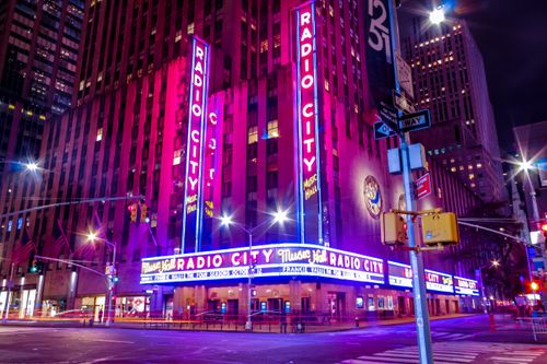 Free Illuminated facade of Radio City Music Hall glowing in neon at night in New York City. Stock Photo