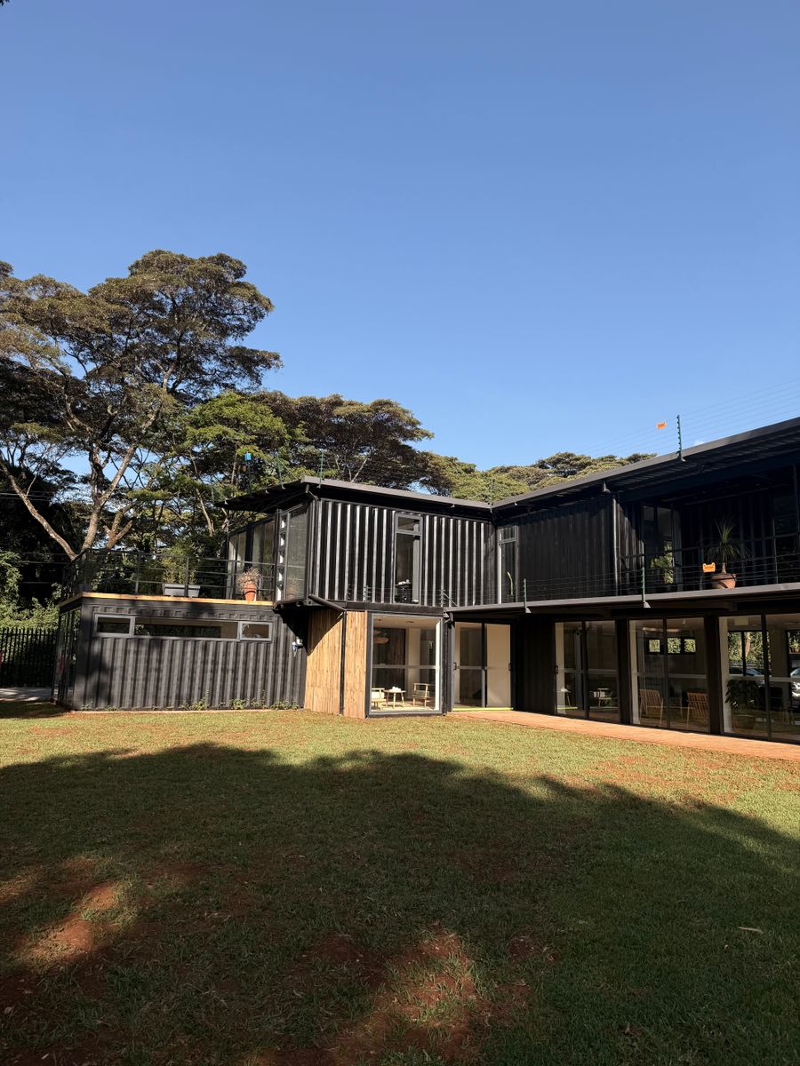 Casa modular construida con contenedores, con grandes ventanales y jardín