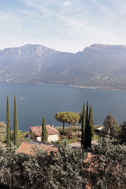 Free Scenic view of Lake Garda surrounded by mountains and villas in Italy. Stock Photo