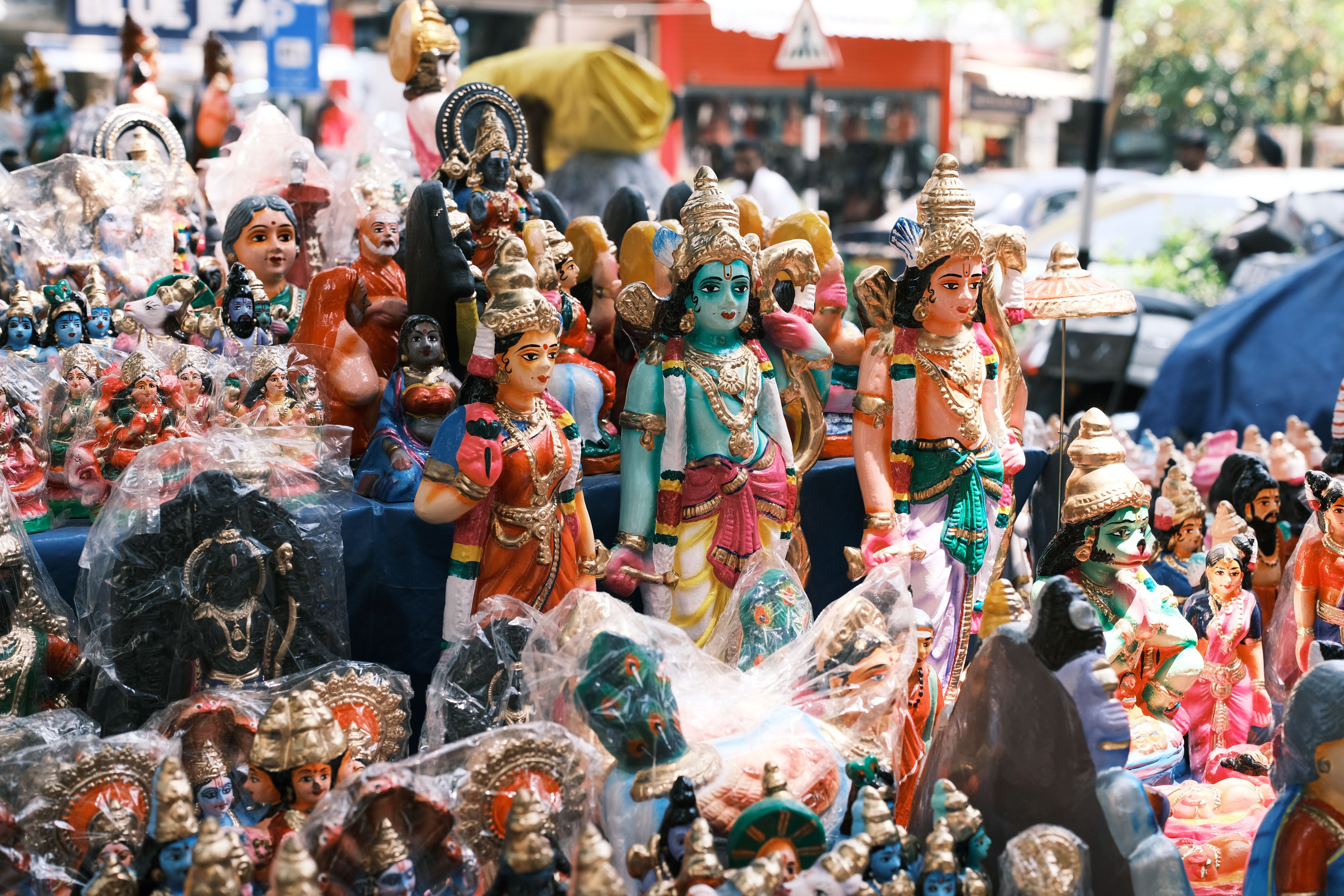Vibrant display of Hindu deity statues at an outdoor market in Bengaluru, India.