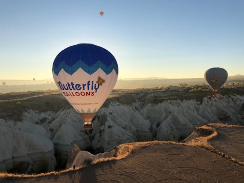 Blue And White Hot Air Balloon Floating Over the Mountains