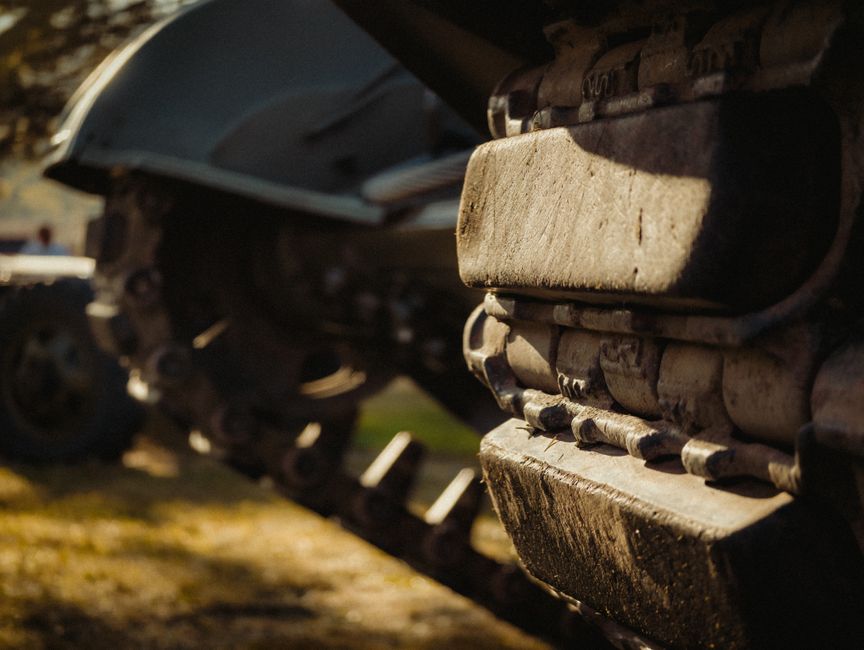 Detailed close-up of military tank treads highlighting rugged texture and outdoor setting.