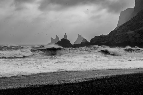 Free Captivating black and white capture of Iceland's iconic Reynisfjara beach with striking sea stacks and crashing waves. Stock Photo