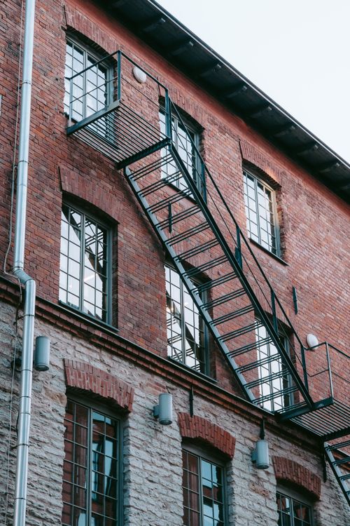 Free Captivating view of a historic brick building facade and fire escape stairs in Tallinn's Rotermann Quarter. Stock Photo