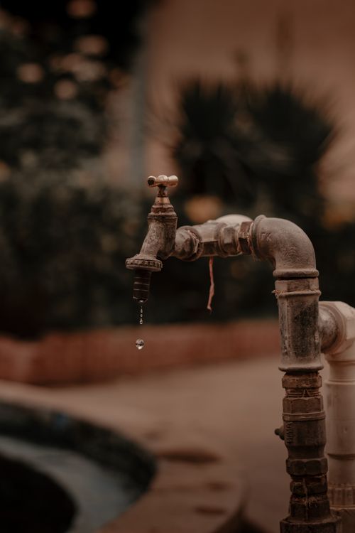 Free Close-up of a dripping tap, showcasing rustic charm in an outdoor setting in Kermanshah, Iran. Stock Photo