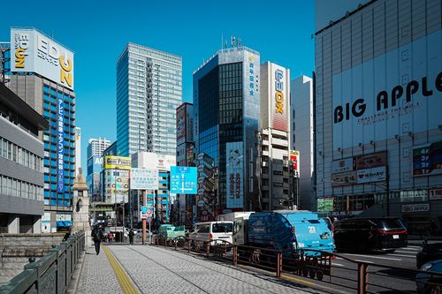 Free Busy city street in Chiyoda City, Tokyo with skyscrapers under a clear blue sky. Stock Photo