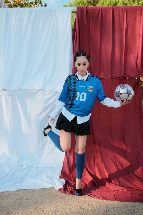 Free Fashionable portrait of woman in soccer jersey holding ball, outdoors backdrop. Stock Photo