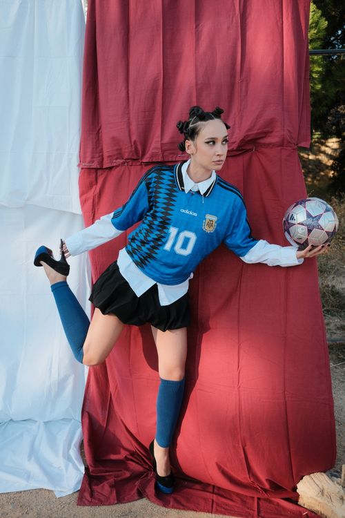 Free Young woman in sports fashion posing with a soccer ball outdoors. Stock Photo