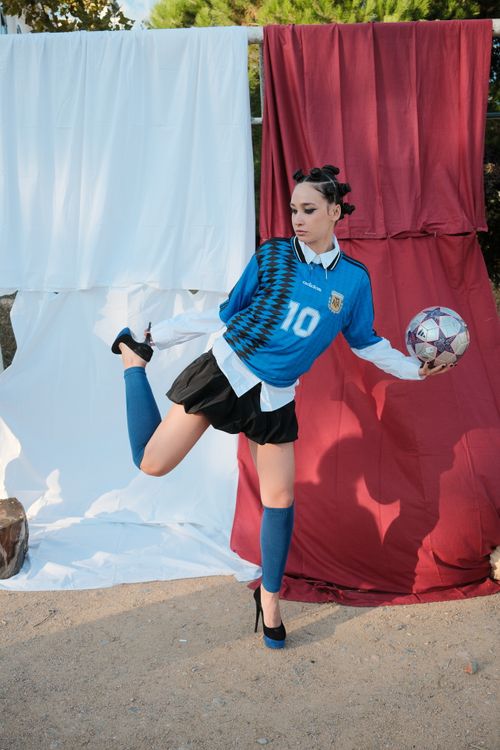 Free Fashionable soccer player in blue jersey poses with a soccer ball outdoors Stock Photo
