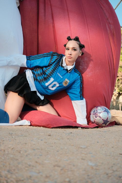 Free Fashionable model in sports attire posing with soccer ball outside, conveying energy and style. Stock Photo