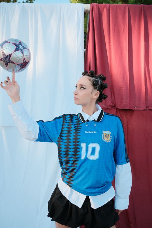 Free A young adult skillfully balances a soccer ball on their finger. Stock Photo