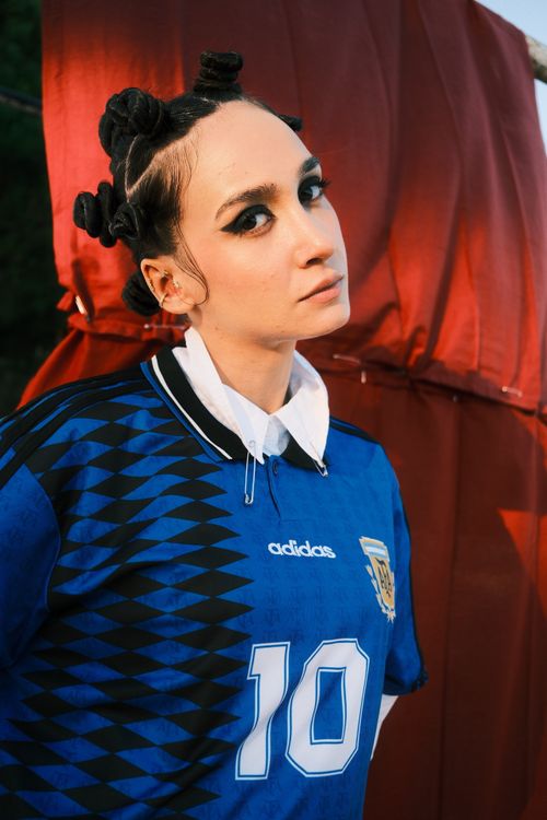 Free A fashionable woman wearing a blue sports jersey with bold makeup and unique hairstyle. Stock Photo
