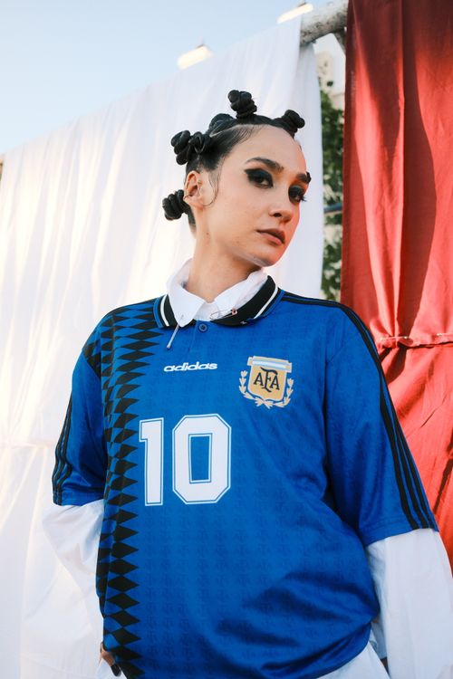 Free Woman in a blue soccer jersey with unique hairstyle posing outdoors. Stock Photo