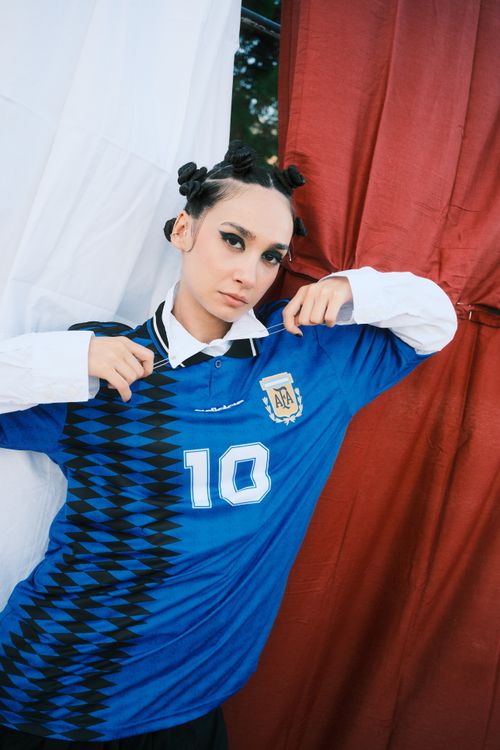 Free Model in stylish soccer jersey showcasing bold fashion statement with artistic flair. Stock Photo