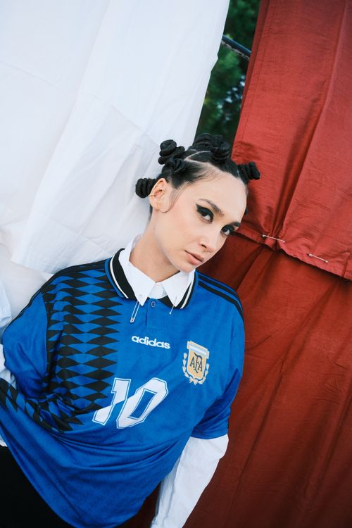Free Stylish portrait of a woman in a soccer jersey with unique hairstyle and dramatic makeup. Stock Photo