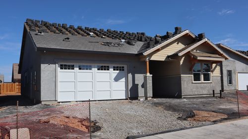 Free Modern suburban home under construction showcasing roof tiles being installed against a clear sky. Stock Photo