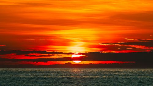 Free Dramatic sunset view over the ocean at Cửa Tùng, Vietnam with vivid orange and red hues. Stock Photo