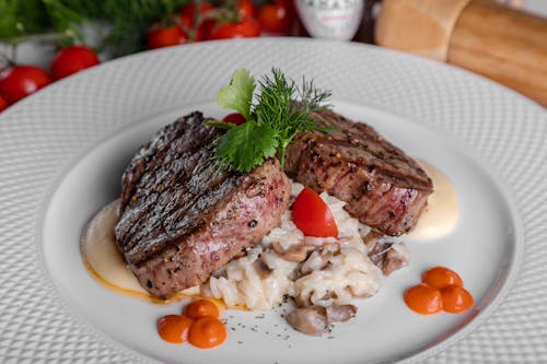 Meat With Sliced Tomatoes On White Ceramic Plate