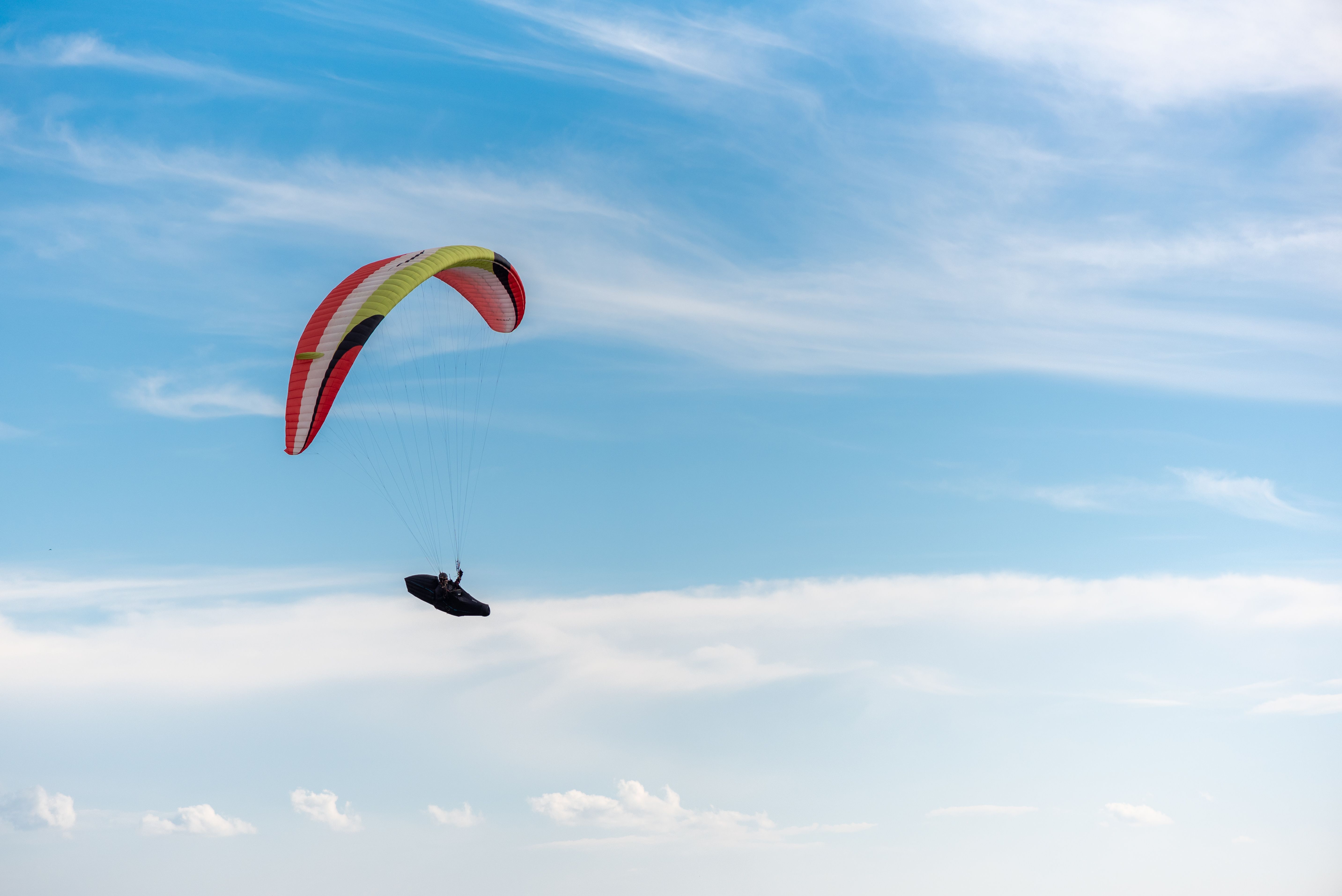 Paraglider flying under a clear sky in Brumadinho, Brazil