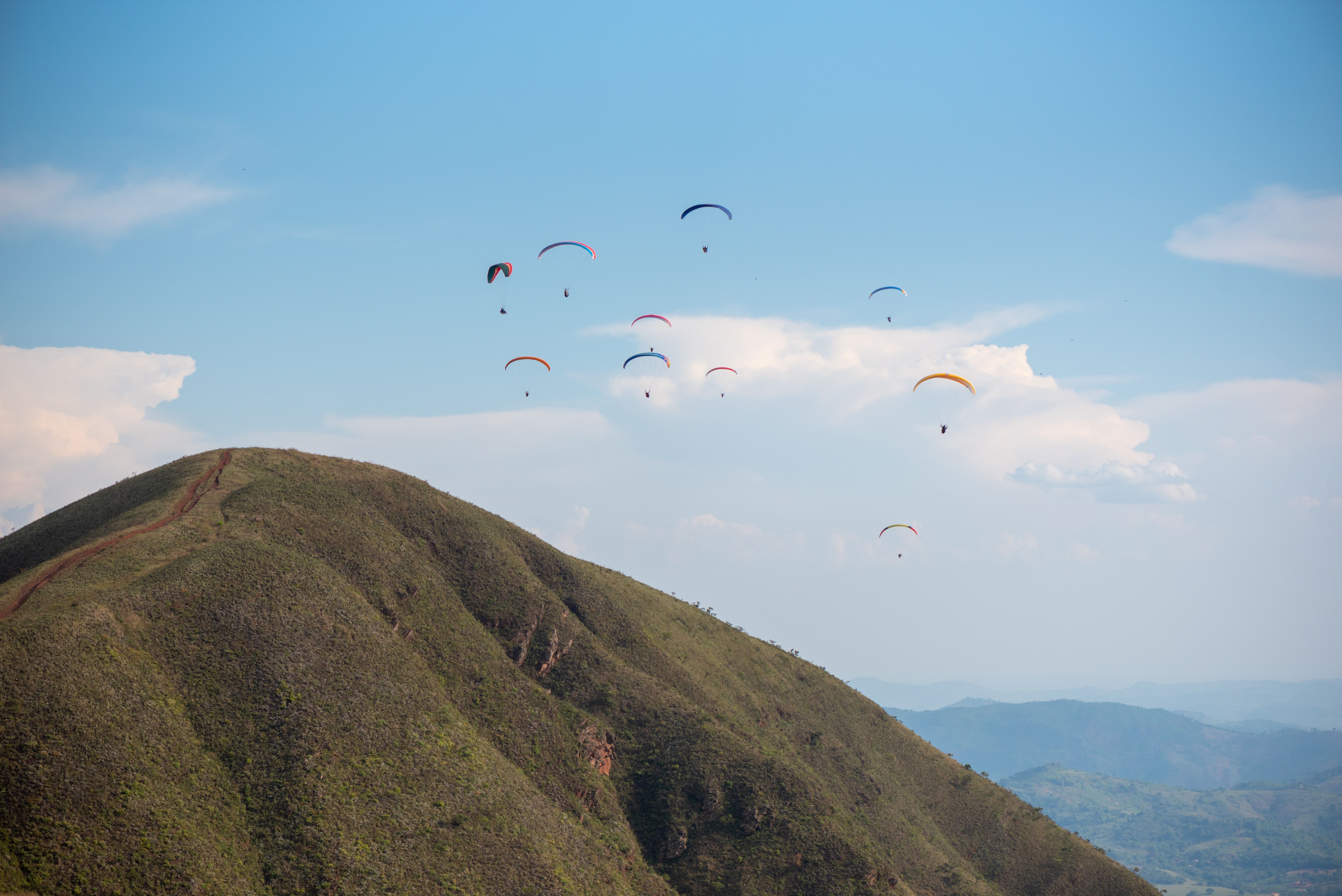Scenic view of paragliders soaring above lush greenery in Brumadinho, Minas Gerais, Brazil.