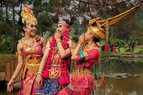 Free Three women in traditional Indonesian costumes at a scenic park in Bandung, showcasing vibrant cultural attire. Stock Photo
