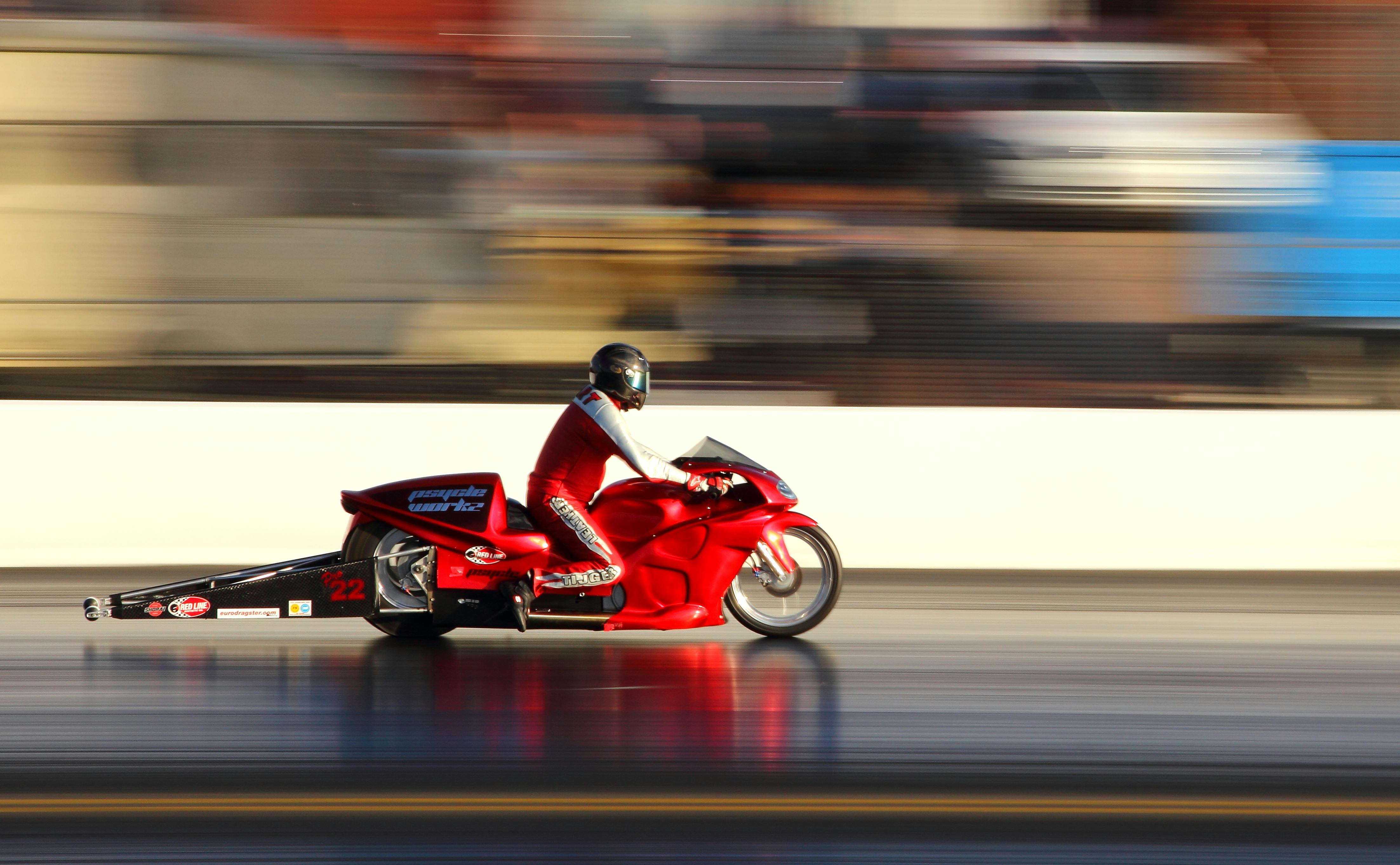 man riding red sports bike