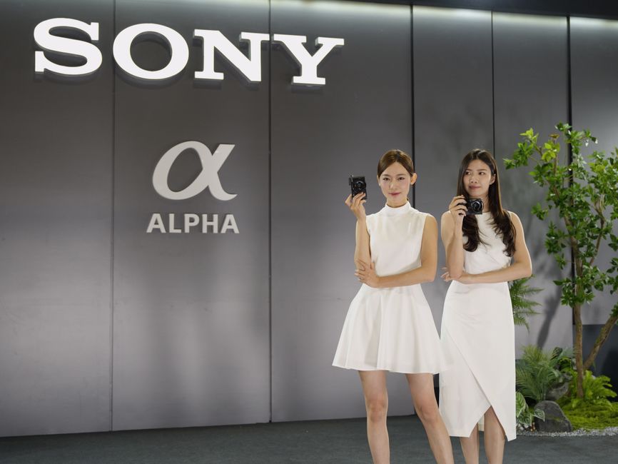 Two women posing with cameras at a tech exhibition in Taipei, Taiwan.