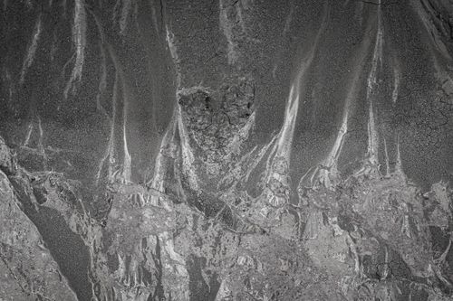 Free Abstract aerial image showing eroded riverbed textures and patterns in grayscale tones. Stock Photo
