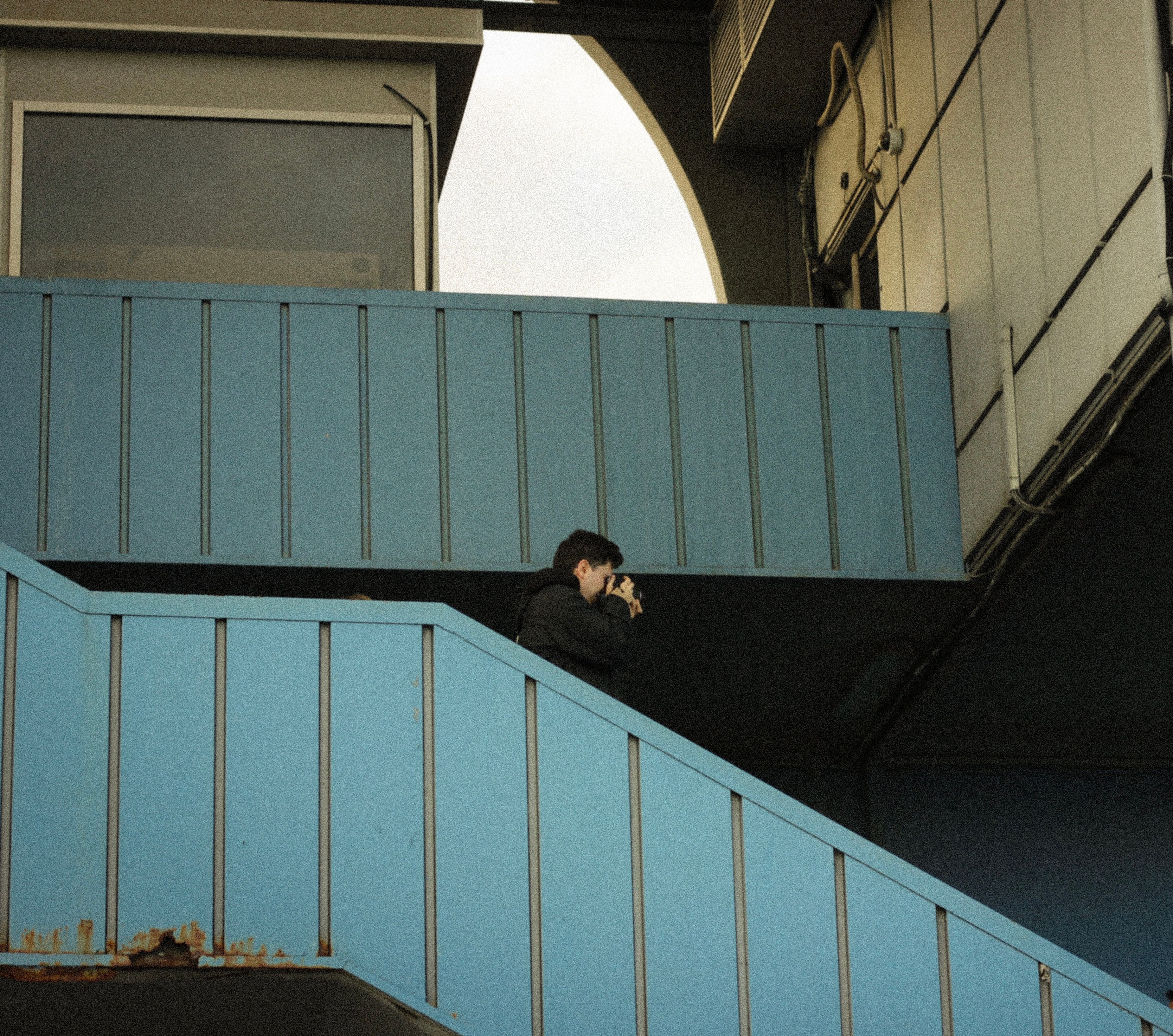 Urban scene featuring a photographer capturing moments on a blue staircase.