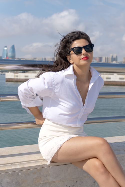 Free Confident woman in sunglasses enjoying a sunny day by the Caspian Sea in Baku. Stock Photo